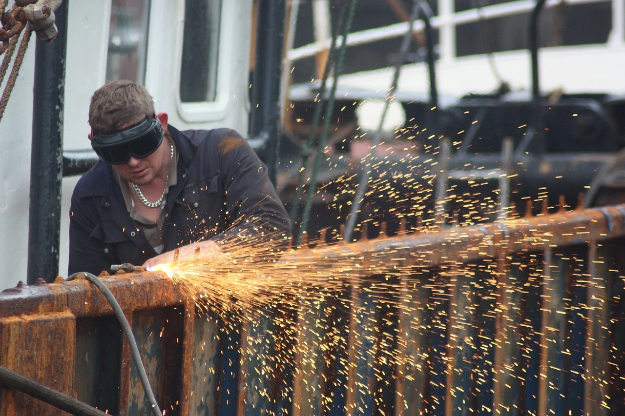 This picture shows a man welding. it is is a fundamental process in metal fabrication and construction that involves joining two or more pieces of metal together using heat and pressure.